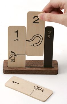 a hand is holding a wooden block with numbers on it and an arrow in the middle