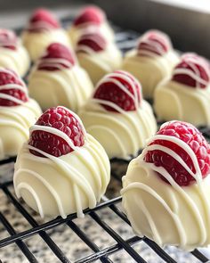 chocolates with raspberries and white frosting on a cooling rack, ready to be eaten