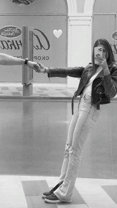 a woman is taking a selfie in front of coca - cola signs with her cell phone