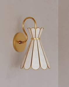 a wall light that is on the side of a wall with a white and gold design