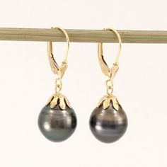 Brand New Solid Yellow Gold (not plated, not bonded) Tahitian Pearl Earrings Beautiful and unique well match dangle earrings. These Tahitian pearls finished with 14k solid yellow gold lever back and flower cap design. This genuine baroque Tahitian pearl earring is the epitome of natural beauty, grace. They are gaining popularity because of their unique look. The shimmering Tahitian pearl size is approximately width of 10.6mm. Due to their nature, no two pearls are alike, their nature making each pearl is one of kind. Therefore; we must send out exact pair on this listing if you purchase it. 1.Main Stone: Tahitian pearl 2.Color: Natural Black 3.Earring Size: approximately 10.6 mm width x 31mm length from bottom to the top (0.42 x 1.22 inches) 4.Earrings Total Weight: approximately 4.4 Grams Tahitian Pearl Earrings, Black Pearl Earrings, Pearl Jewels, Tahitian Black Pearls, Pearl Dangle Earrings, Pearl Earring, Tahitian Pearls, Pearl Earrings Dangle, Pearl Charms