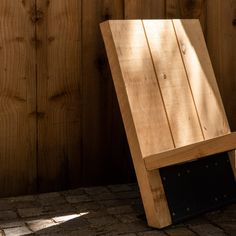 a wooden chair sitting on top of a brick floor