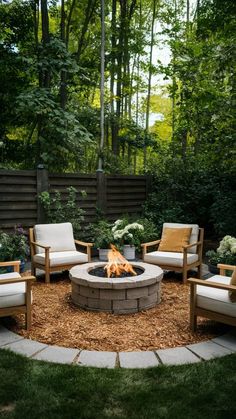 an outdoor fire pit surrounded by chairs and plants in the middle of a garden area