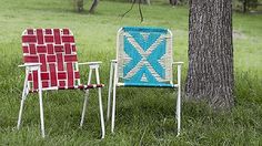 two lawn chairs sitting next to each other in the grass near a tree and grassy field