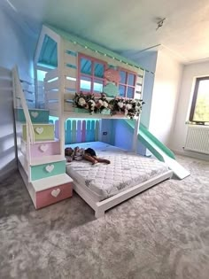 a child's bedroom with bunk beds, stairs and flowers on the window sill