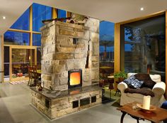 a living room filled with furniture and a fire place in the middle of it's walls