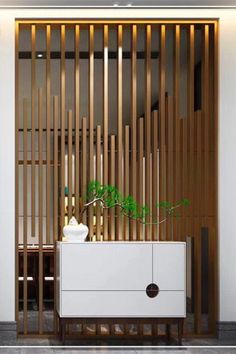 a white cabinet sitting in front of a wooden wall with vertical slats on it