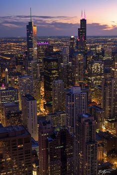 the city lights shine brightly at night in this aerial view from above, with skyscrapers and other high rise buildings