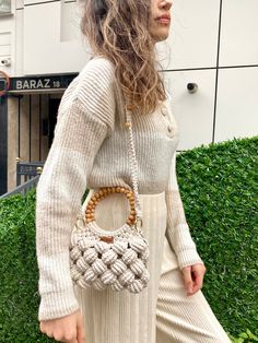 a woman carrying a woven bag in her hand