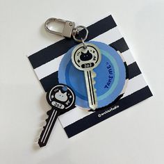 a keychain that has a cat on it and is attached to a card