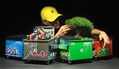 a man holding a small tree in front of a box filled with toys and other items