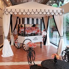 a white and black wedding tent with flowers in it