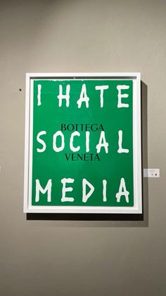 a green sign that says i hate social media on the side of a gray wall