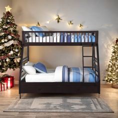 there is a bunk bed with blue and white sheets on it next to a christmas tree