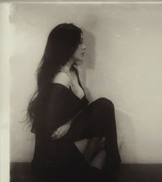 a black and white photo of a woman sitting on the floor