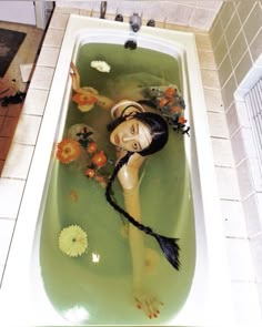 there is a woman in the bathtub with flowers on her head and long hair