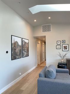 a living room filled with furniture and pictures on the wall