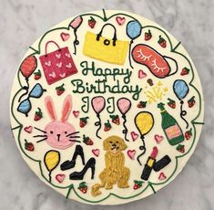 a birthday cake decorated with various items on top of a marble countertop in the shape of a circle