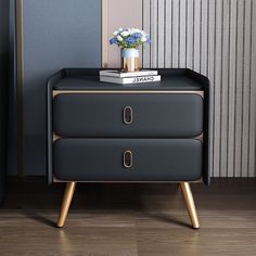 a black and gold nightstand with flowers on it next to a blue striped wallpaper