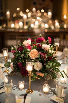 the centerpiece is surrounded by candles and flowers