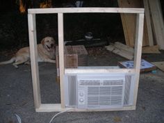 a dog is sitting in front of an air conditioner