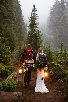 the bride and groom are walking through the woods with their backpacks full of flowers