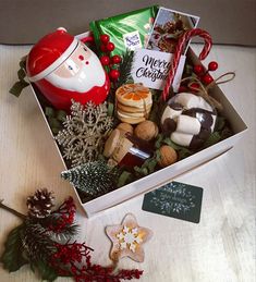 a christmas gift box filled with cookies, candies and other holiday treats sitting on a table