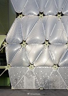 a large stack of plastic plates sitting on top of a metal rack in front of a building