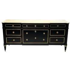 a black and white dresser with gold trimmings on the bottom, two drawers and one door