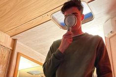 a man holding a hair dryer in front of his face