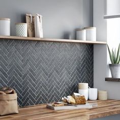 a kitchen counter with some bread and cups on it