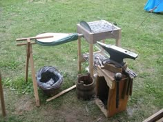 an outdoor work bench made out of wood and various tools sitting on the ground next to it