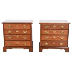 a pair of wooden chests with gold decorations on each drawer and one has a marble top