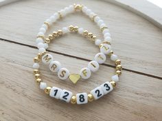 "This adorable bracelet set is perfect for a bride to be! The price is for both bracelets, but they can also be purchased separately if you only want one.  One bracelet says \"Mrs.\" and the bride's new last name. This bracelet is made with a gold 18k gold plated heart bead separating the Mrs. and the last name, white glass 4mm round beads, and 24k gold plated bumpy rondelle accent beads. It also has a gold plated round bead to cover the knot. The letters used are round white acrylic with gold l Bride Clay Bead Bracelet, Bracelet Team Bride, Gold Name Bracelet For Wedding, Customizable Bracelets For Weddings And Mother's Day, White Charm Bracelet For Anniversary On Mother's Day, Elegant Letter Beads Jewelry For Wedding, Customizable Wedding Bracelets, White Letter Beads Name Bracelet For Wedding, Personalized Beaded Bracelets For Wedding