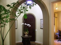 a vase with white flowers sitting on top of a table in front of a doorway