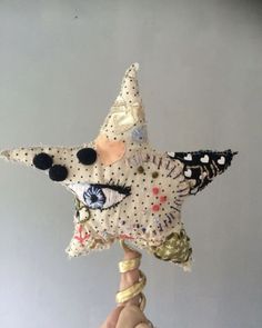 a hand holding up a decorative star ornament