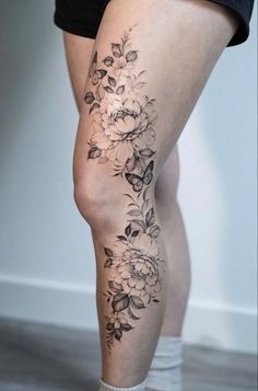 a woman's leg with flowers and butterflies on it, showing her lower legs