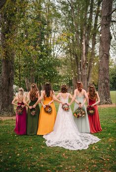 a group of women standing next to each other on top of a lush green field