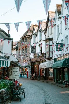 the flags are hanging over the shops on the side of the street in front of them