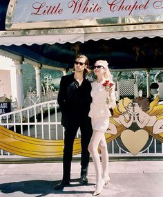 a man and woman standing in front of a carousel