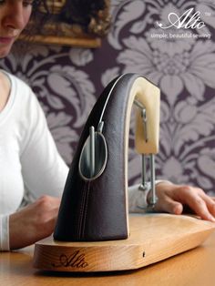 a woman sitting at a table working on an old fashioned sewing machine in front of her