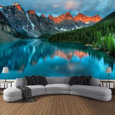 a couch sitting in front of a large wall mural with mountains and trees on it