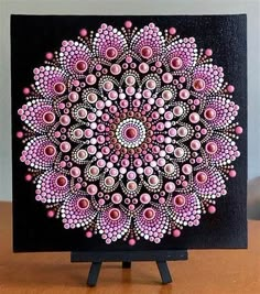 a black and pink painting on top of a wooden table