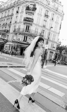 a woman in a wedding dress is walking down the street