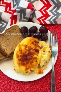 an omelet on a plate with bread and olives next to a fork