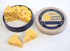 several pieces of cheese sitting next to each other on a white surface with blue tins