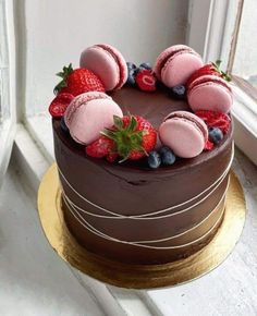 a chocolate cake with strawberries and blueberries on top