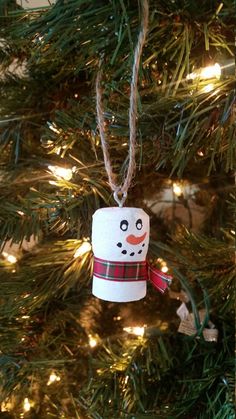 a snowman ornament hanging from a christmas tree