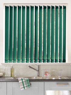 a kitchen with green blinds in the window