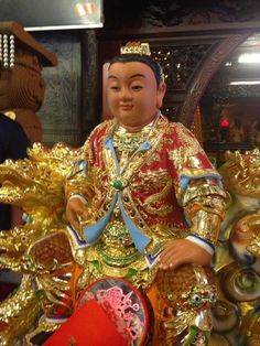 a statue of a man sitting on top of a golden dragon